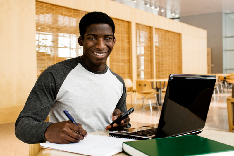 African school leaver studying with a laptop